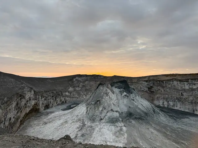 Volcanic crater formations beneath an orange horizon